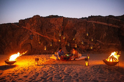 Evening fire-pit terrace against the rock face at Alila Hinu Bay, Oman