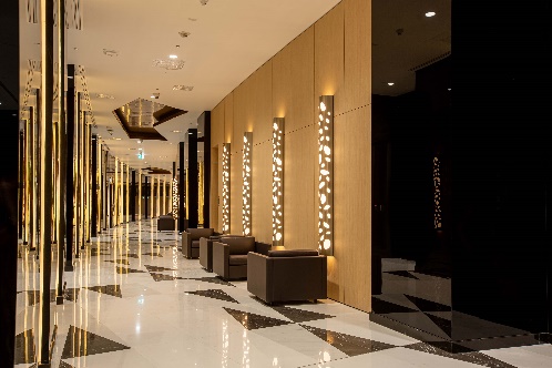 Lobby corridor interior at QatarEnergy headquarters, Doha, with backlit stone screens